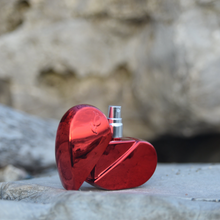Load image into Gallery viewer, Clean, safe, non-toxic fragrance at it's best! Packaged in a refillable, recyclable cherry red and reflective, aluminum heart-shaped glass bottle, this gourmand fragrance is an ode to love. The combination of aphrodisiac essential oils and warm, full bodied resins of tonka bean , benzoin and ylang ylang, topped with a refreshing citrus note of lemon, LEV makes for an original scent that is one-of a kind. Lev is seductive, sophisticated, simple and sweet all at once.