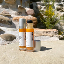 Load image into Gallery viewer, A shimmering gold, therapeutic perfume roll on, Kavana's Neroli Calm Blend, is a light, citrus and white flower fragrance that can help calm anxiety, and increase positive feelings. A must-have purse fragrance. Essential oils of Neroli, tangerine, petitgrain bigarade, sweet orange and bergamot blend beautifully in meadowfoam and rice bran oil for a long-wearing, lightly moisturizing, skin friendly fragrance. A soft golden shimmering mica, leaves a shimmer on the skin after applying it.
