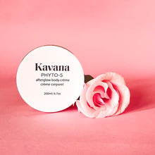 Load image into Gallery viewer, Kavana's Phyto-5 Afterglow Body Cream is light but luscious and perfectly layers under Kavana's lighweight Afterglow Body oil. Seal moisture in skin all season with these two. Seen here, the cream lies flat on a rock, opened, the cover lies flat on the upper right hand side of it. The cream is a pale ivory yellow tone. Perfect or those who intentionally seek to embody intention, using non-toxic, hormone safe, plant powered skincare.