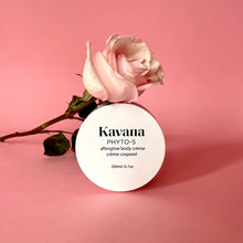 Load image into Gallery viewer, Kavana's Phyto-5 Afterglow Body Cream is light but luscious and perfectly layers under Kavana's lighweight Afterglow Body oil. Seal moisture in skin all season with these two. Seen here, the cream lies flat on a rock, opened, the cover lies flat on the upper right hand side of it. The cream is a pale ivory yellow tone. Perfect or those who intentionally seek to embody intention, using non-toxic, hormone safe, plant powered skincare.