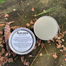 Load image into Gallery viewer, Kavana Phyto-5 Boreal Beard Balm pictured here on a tree stump, opened, with some pine cones around it. Pale green, thanks to the kaolin and French Green clays in it, this balm is smooth and tacky at the same time. This lightweight pomade can be used to style and groom the beard hair.