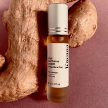 Load image into Gallery viewer, PMS cramps got you down? Find support with this Plai (Thai Ginger) roll on. Try Kavana's powerful Perfume Poem blend, including Plai (Thai ginger) and Marjoram essential oils, to help ease the pain of monthly cramps.  Seen in this photo: a roller ball on rosted glass bottle 10ml, with a matte silver cap, resting on a large piece of fresh ginger.