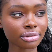 Load image into Gallery viewer, Model Raissa is seen in close up wearing Kavana&#39;s Phyto-5 Tinted lip oil in shade Sublime- a sheer metallic rose gold with silvery ndertones.
