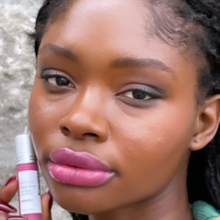 Load image into Gallery viewer,  Kavana&#39;s Phyto-5 Tinted Lip Treatment oil in Eglantine, a bright fucshia, with blue undertones. The bottle sits atop a love note that says &#39;mon amour&#39; with a bright fuschia kiss mark on it!
