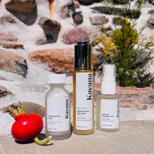 Load image into Gallery viewer, Kavana&#39;s La Vie En Rose skincare Trio includes the Purifying Face Mask, Restorative Rose Nectar, Reviving Rose Glow Mist, all in 30ml formats. There is a large rosehip to the left of these bottles in the photo, and a stone wall in the background.
