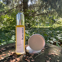 Load image into Gallery viewer, Kavana&#39;s Phyto-5 Boreal Beard balm, comes in a small,reusable and recyclable aluminum tin. Seen here on the forest floor, amongst the pine cones and twigs and beside the Kavana Phyto-5 Conditioning Beard Oil.

