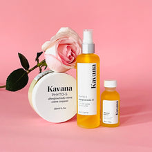 Load image into Gallery viewer, Kavana&#39;s Afterglow trio is plant powered body care at it&#39;s finest. Pictured, our mini travel size body oil, large body oil and large Body Cream, arranged side by side with a pale pink rose resting on the body cream, which is upright. 
