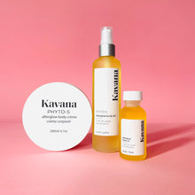 Load image into Gallery viewer, Kavana&#39;s Afterglow trio is plant powered body care at it&#39;s finest. Pictured, our mini travel size body oil, large body oil and large Body Cream, arranged side by side with a pale pink rose resting on the body cream, which is upright. The best of non-toxic, plant powered, hormones safe body care, with Kavana. 
