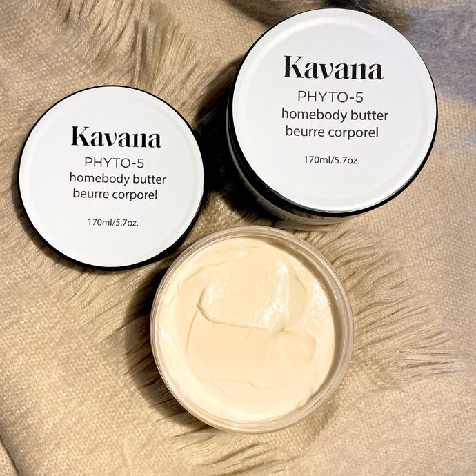seen here, a jar of Body butter open, and another one closed, on a soft looking, beige cashmere scarf. 
