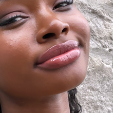 Load image into Gallery viewer, Model Raissa is seen here wearing Kavana&#39;s Phyto-5 TInted lip oil in Seraphine- a rich terracotta brown with orange undertones. It&#39;s a perfect neutral shade on her skin tone- absolutely radiant!
