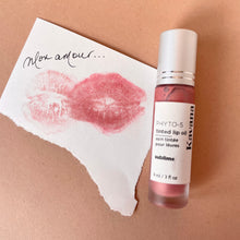 Load image into Gallery viewer, Kavana&#39;s Phyto-5 Tinted Lip Treatment oil in shade Sublime, is a metallic rosy gold shade, with just the right amount of shimmer. The bottle lies flat atop a love note with a lip print that reads &#39;mon amour&#39; my lover in French.
