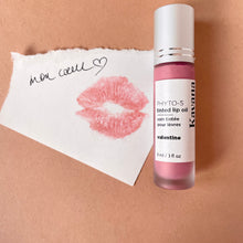Load image into Gallery viewer, Kavana&#39;s Phyto-5 tinted lip treatment oil in shade Valentine, is a sheer, pale  pink with lilac undertones, for lips. Seen closed over top of a love note that reads &#39;mon coeur&#39; my heart in french.  Perfect for kissing and telling on Valentines day!
